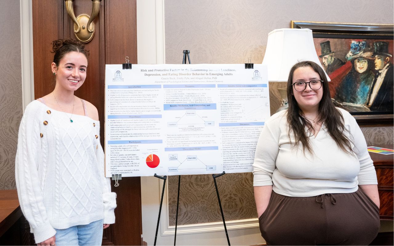 Two students pose with their poster