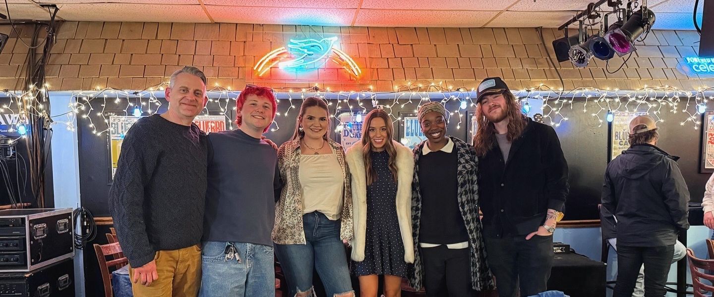 Four students and instructor Drew Ramsey pose at The Bluebird Cafe