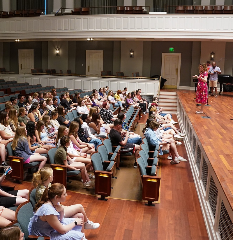 Lesley Mann instructs from stage at a vocal camp in 2022