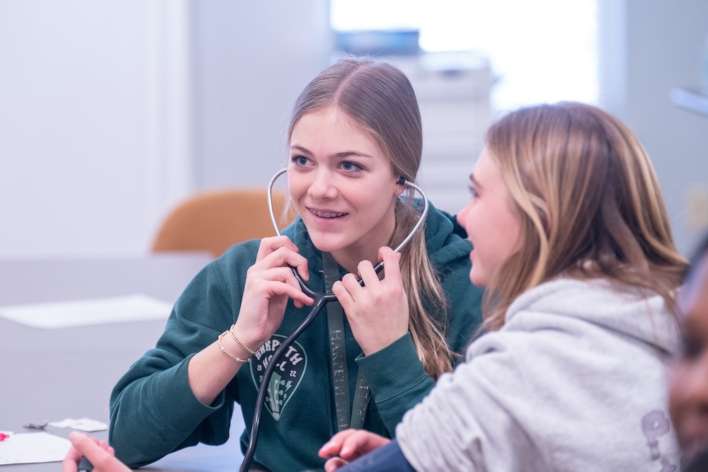 Healthcare 101 students work in simulation lab