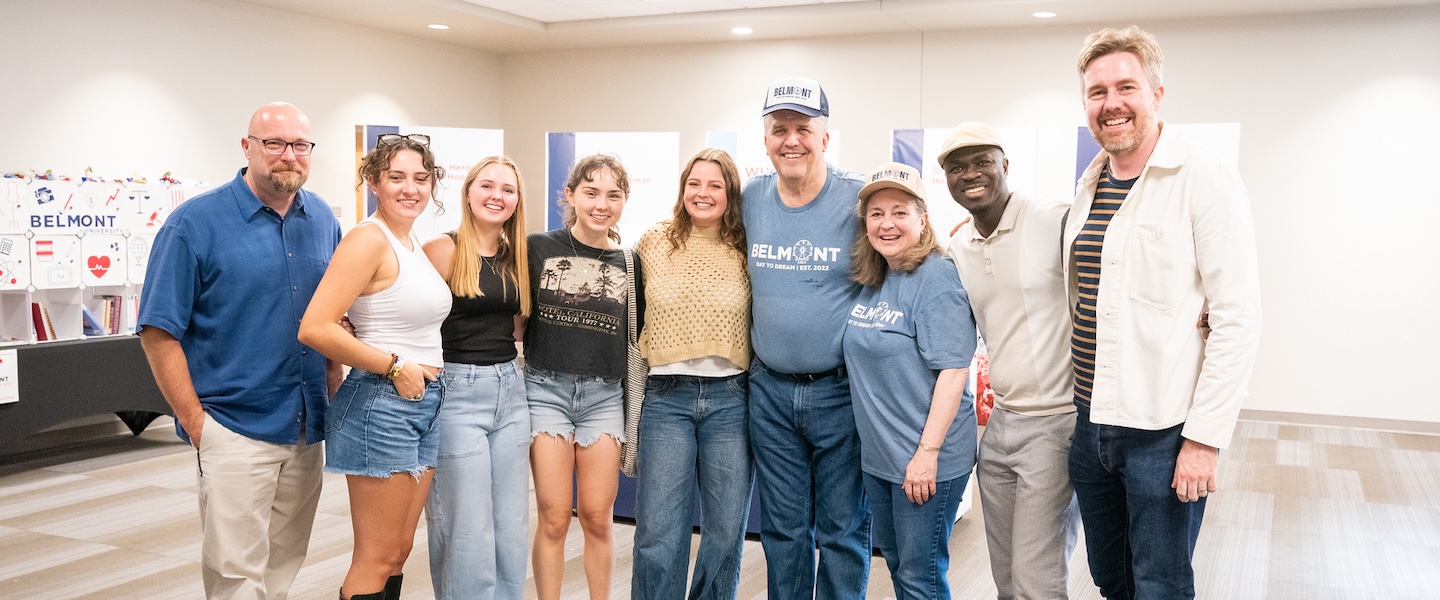 students pose with faculty and the Joneses