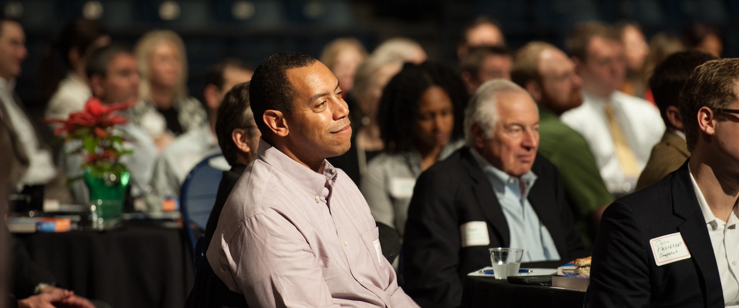 adults sitting together watching a speech