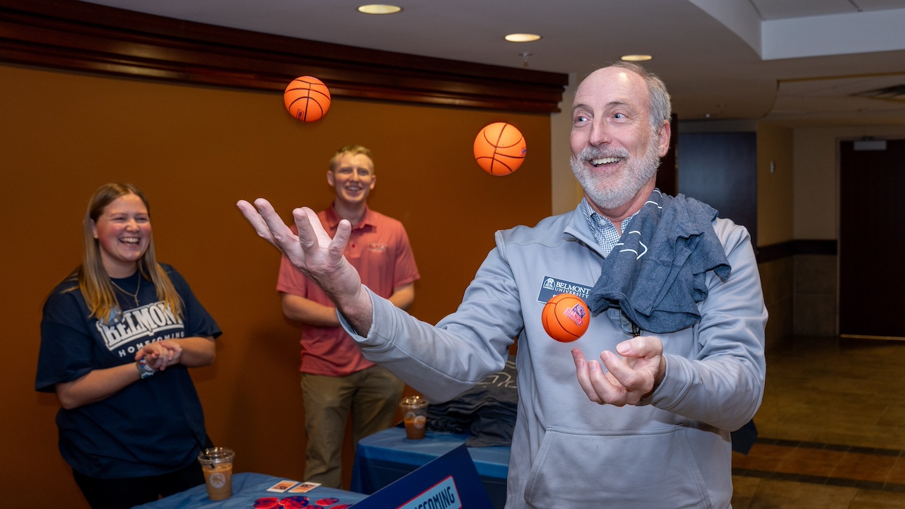 man juggling basketball-shaped stress balls