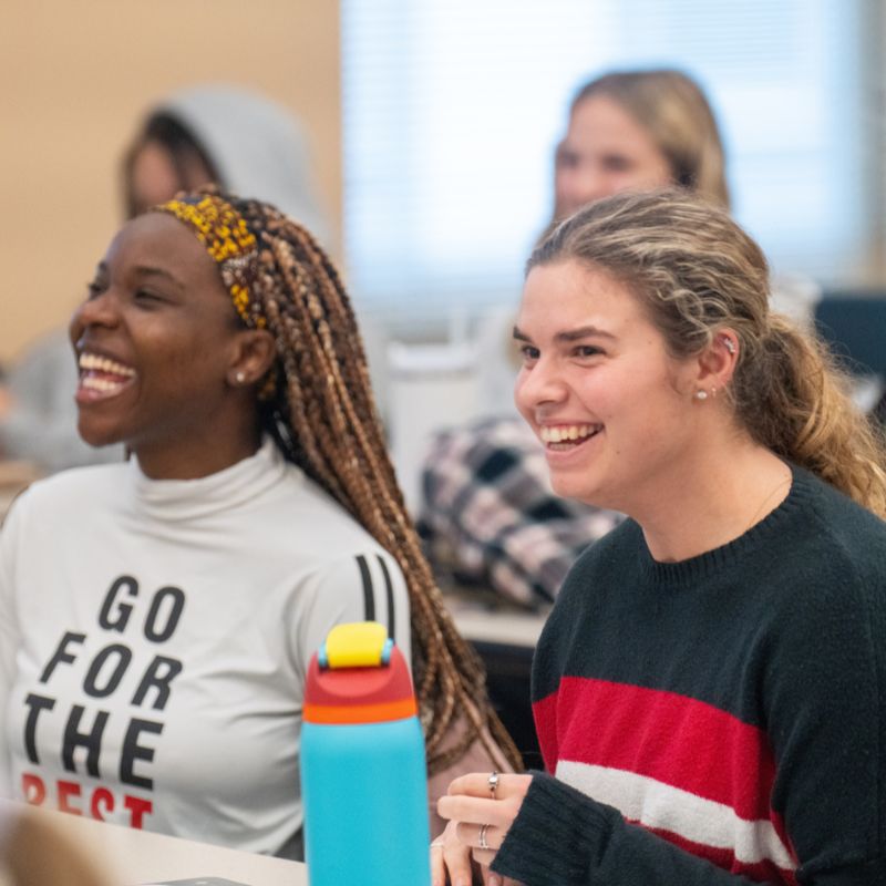 Two students laugh in class