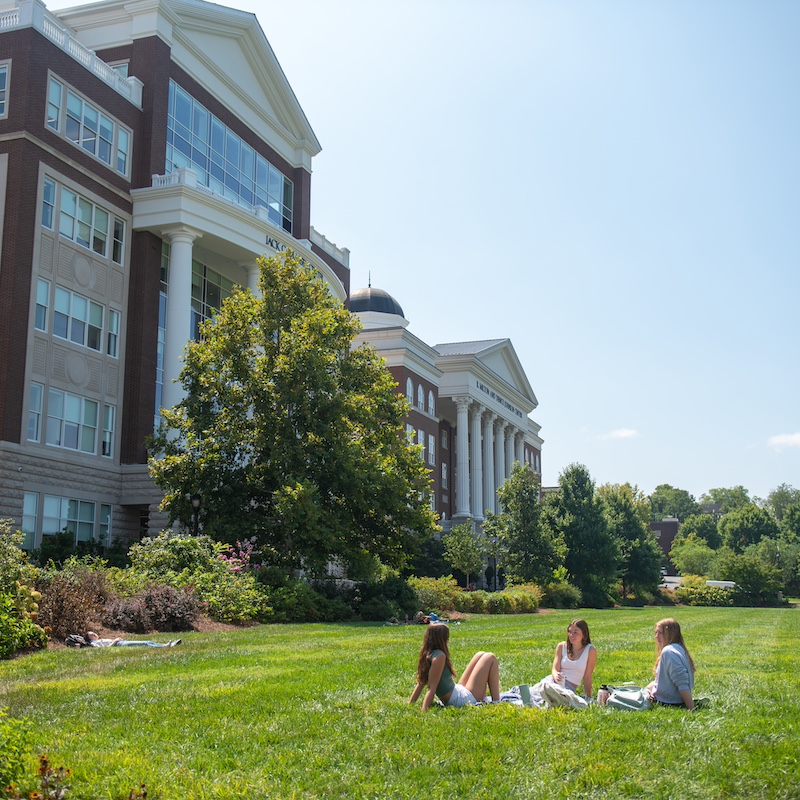 Three students sitting on the Belmont lawn