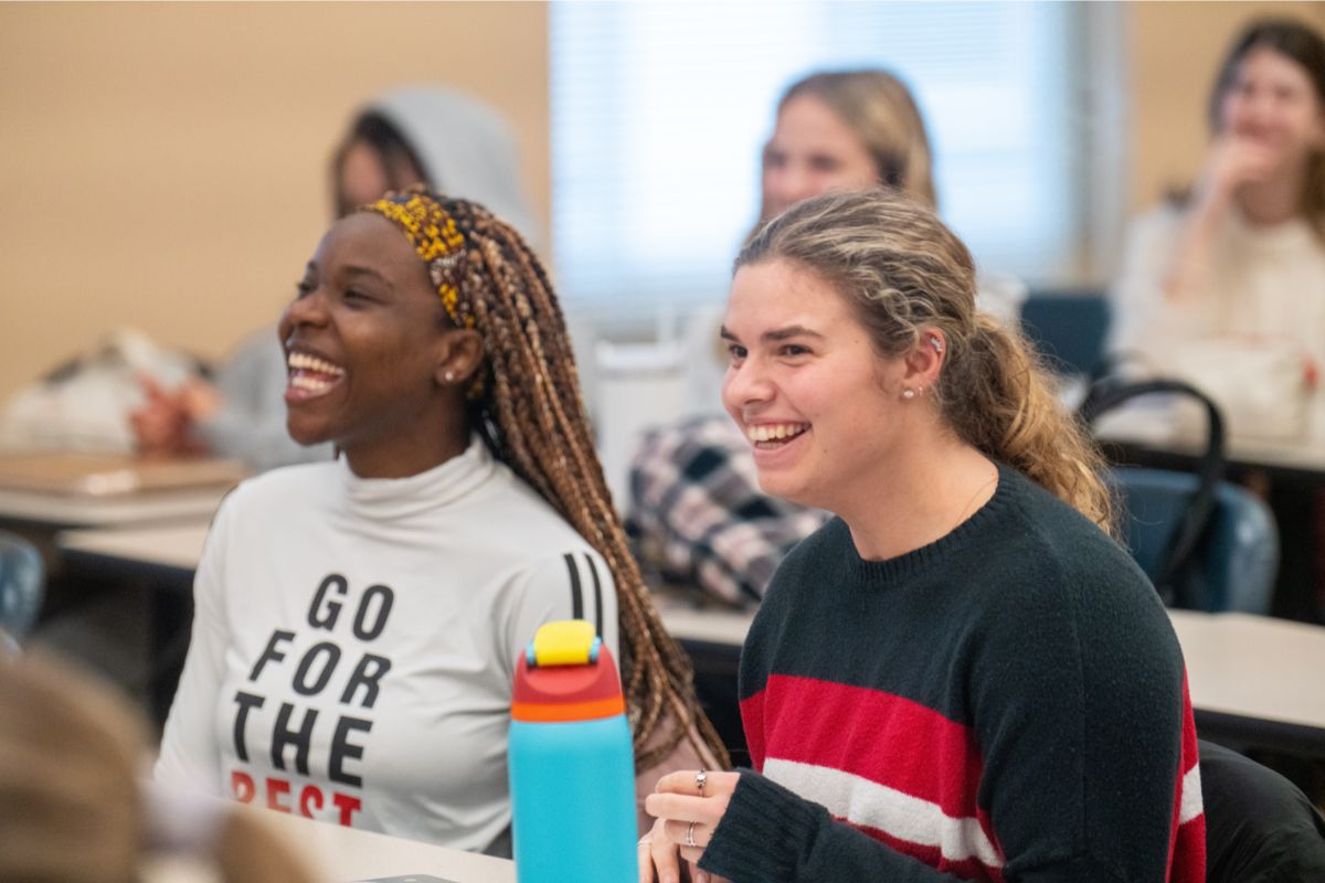 Two psych students laugh in class