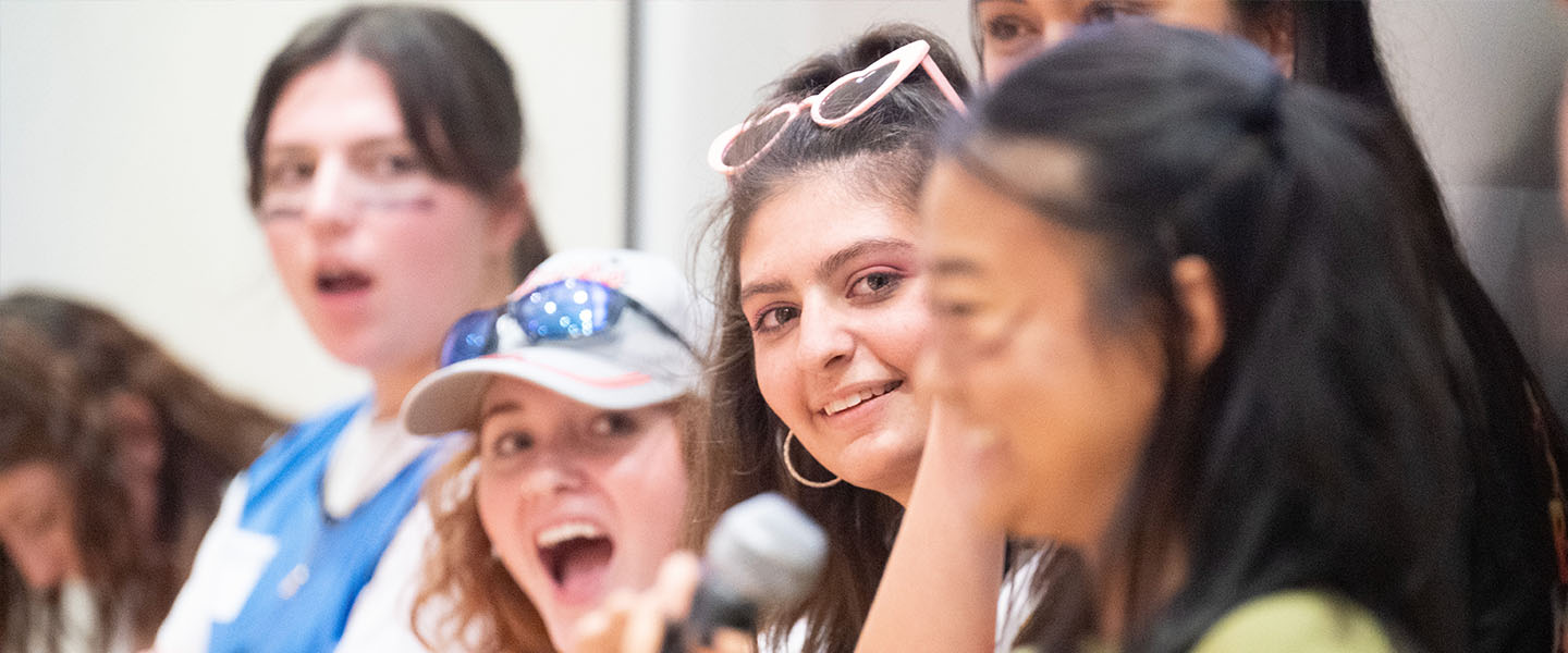 A Tower Team Leader smiles at another as they talk in front of a group