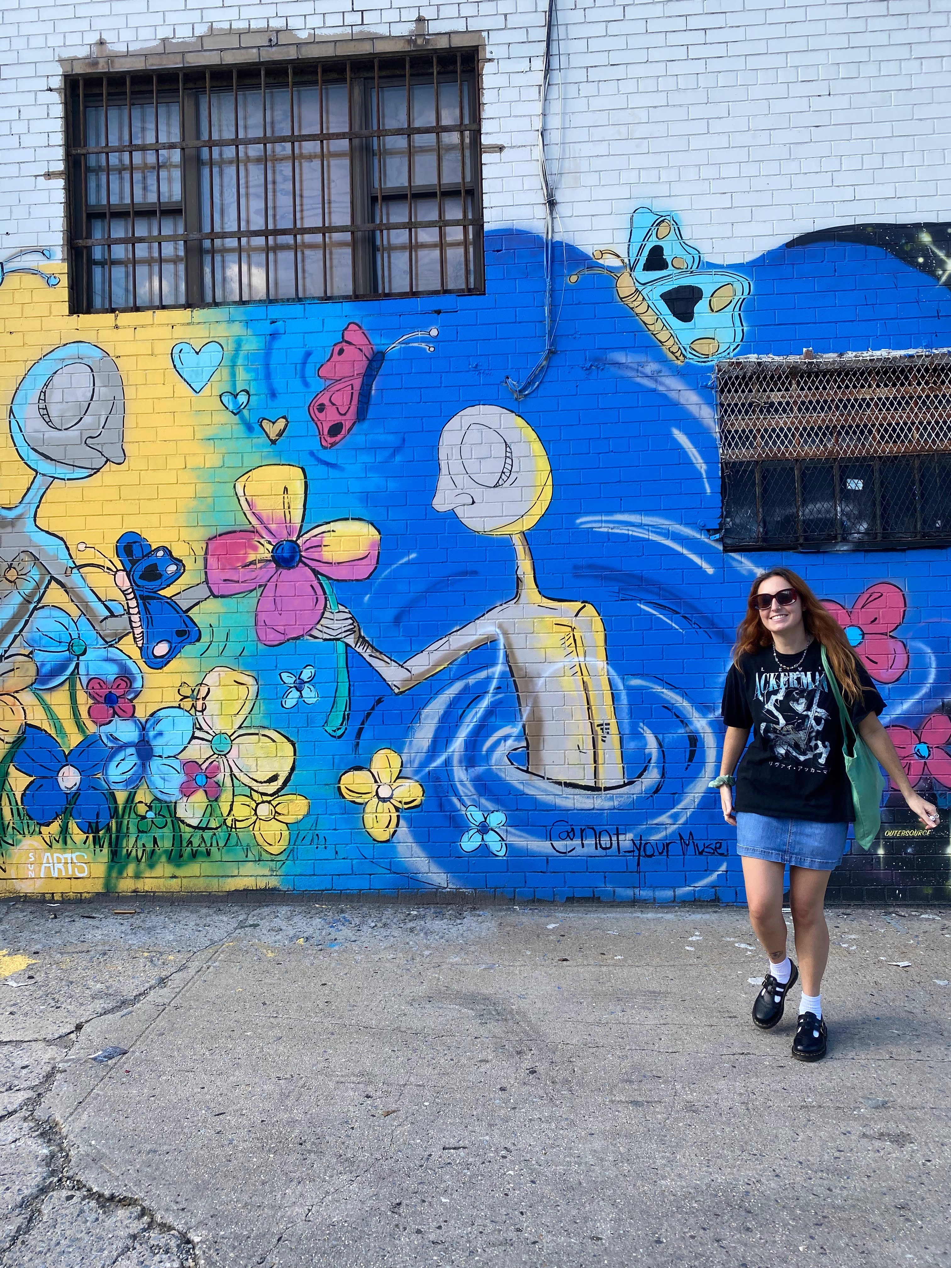 Belmont East student poses for picture in front of mural