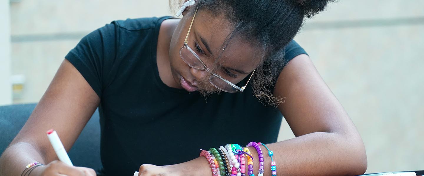 Art student from youth program focusing on an art project in a classroom