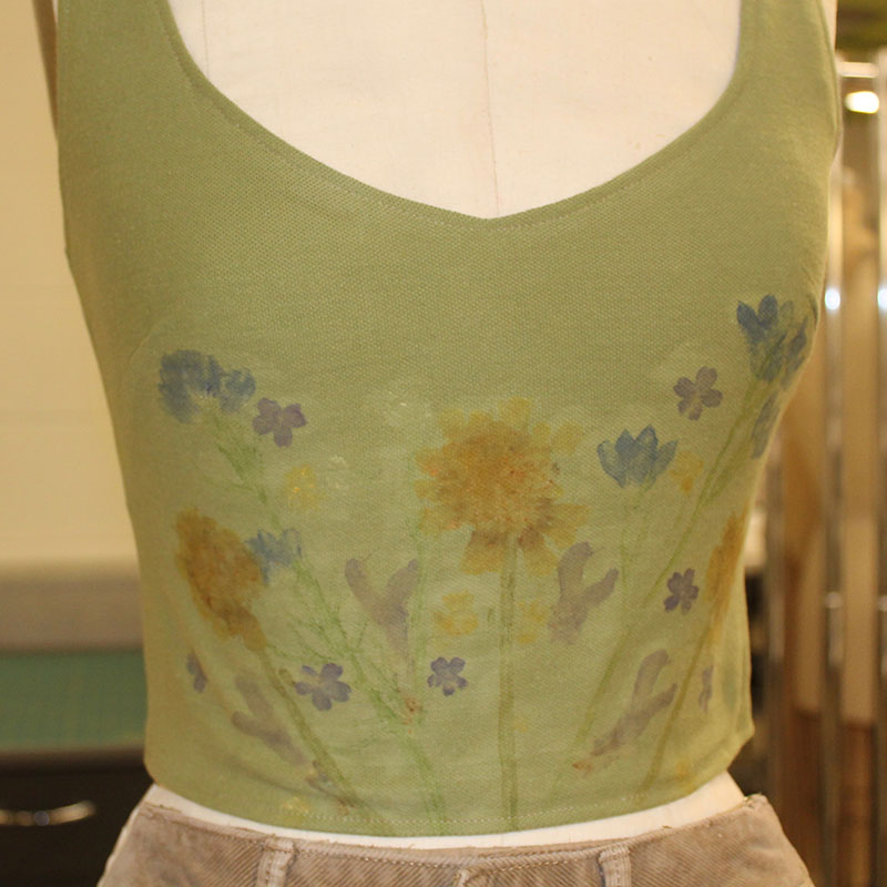 A green top with botanical impressions in blue, yellow, and purple.