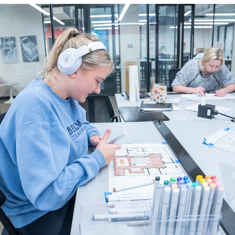 A student works in marker on a sketch.