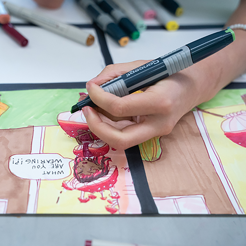 hand holding a marker drawing a comic