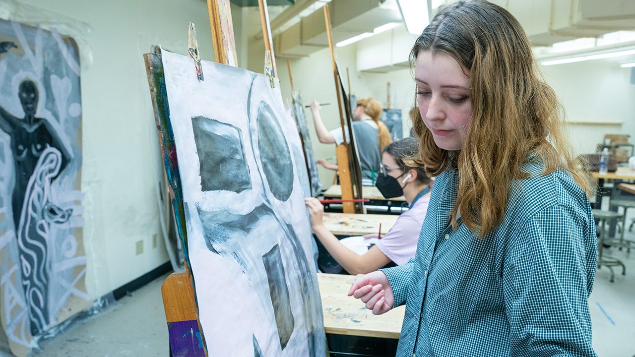 Student drawing on an easel.