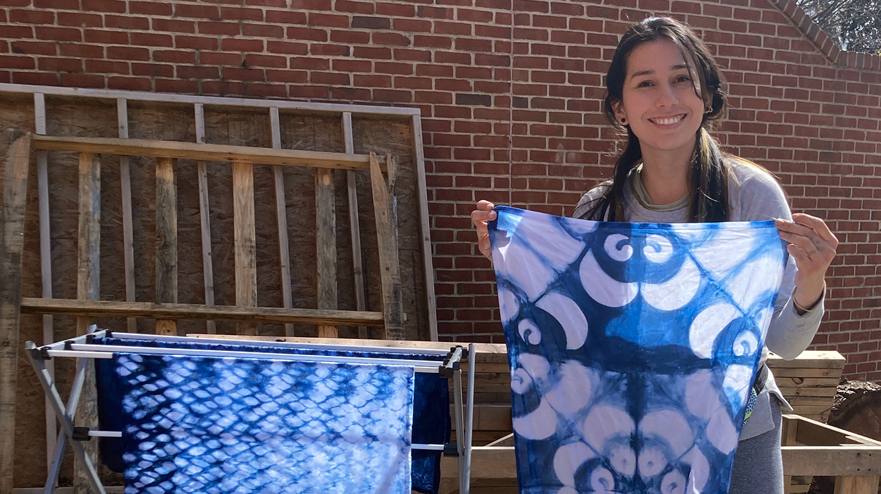 Student holding up indigo dyed handkerchief.